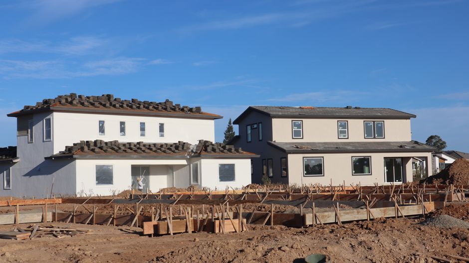 Row of new houses with finished exterior walls and windows.